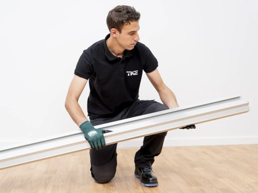 Técnico preparando el raíl para la instalación de una silla salvaescaleras recta