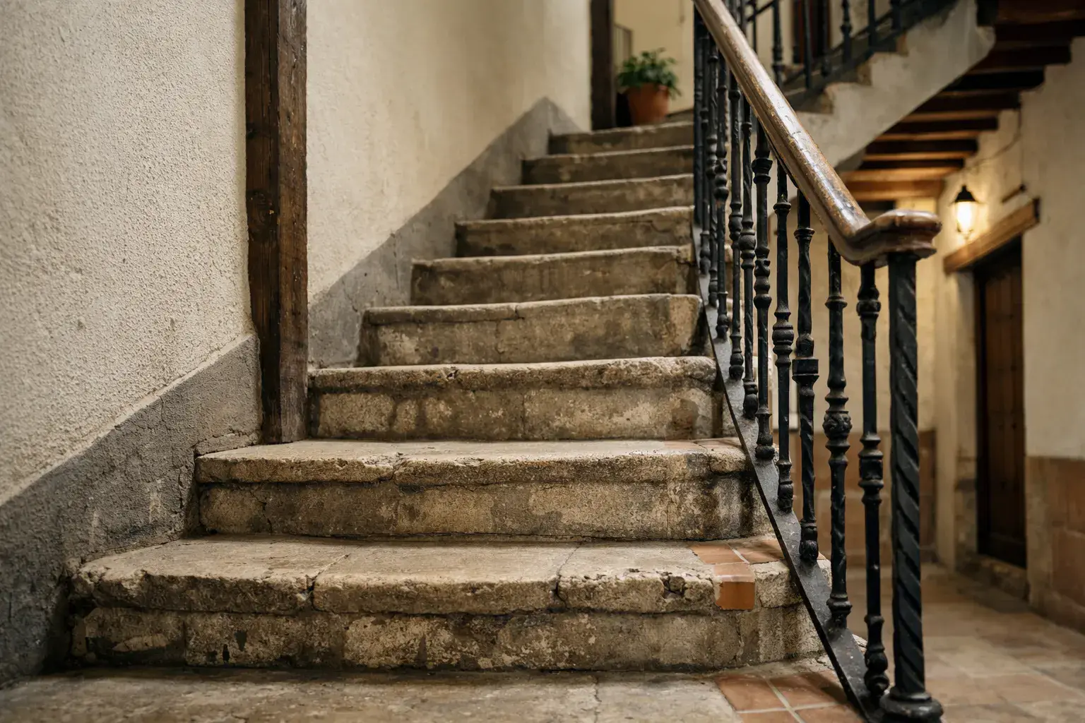 Escalera estrecha de un edificio antiguo de Alcalá de Henares, donde el raíl de una silla de segunda mano rara vez encaja